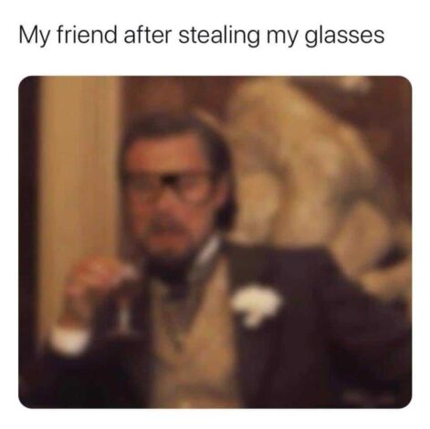 A blurry image of a man in a suit and glasses, holding a drink. The text overlay reads, "My friend after stealing my glasses," which is relatable to anyone needing prescription glasses.