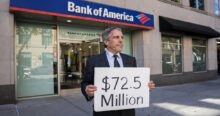 A man stands in front of a Bank of America branch holding a sign that reads "$72.5 Million," referencing the Epstein victims lawsuit settlement. The bank's logo is visible above the entrance. This Epstein bank settlement aims to resolve suspicious activity claims.