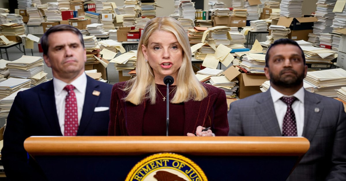 Officials stand behind a Department of Justice podium addressing the press about the Epstein files with stacks of documents in the background.