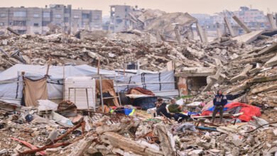Gaza rubble shows the aftermath of conflict as Israel demands staff and financial data from humanitarian organizations. The scene depicts devastation, with people amidst the ruins of buildings. Aid access restrictions are impacting Gaza civilians.
