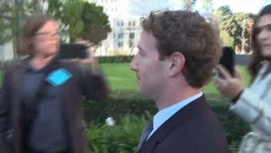 Mark Zuckerberg is seen in profile amidst a social media lawsuit. People hold up phones, capturing the Meta CEO. This image relates to the Meta negligence verdict and platform design liability.