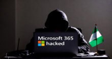 Hooded figure at a laptop with "Microsoft 365 hacked" on the screen, next to a Nigerian flag. This image relates to the recent Microsoft 365 phishing crackdown and arrest of a suspect in Nigeria.