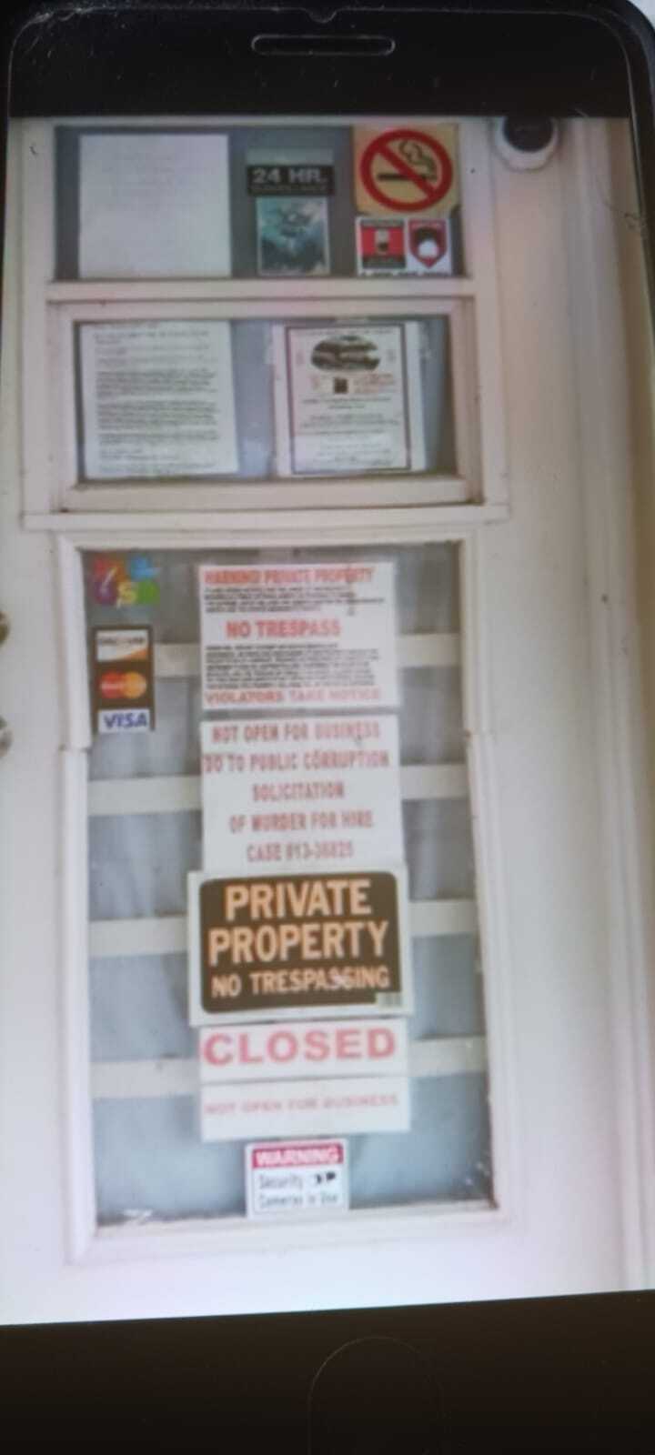 Closed door with "Private Property No Trespassing" sign, warning of security cameras. Other signs include "No Trespass," "Not Open for Business," and a notice about solicitation of murder for hire, referencing case #13-38825. This image relates to the case of Enzo Vincenzi, a North Fort Myers man.