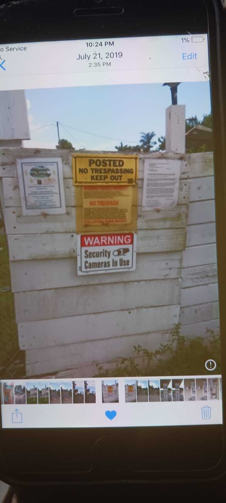 Wooden fence with "Posted No Trespassing Keep Out" and "Warning Security Cameras In Use" signs. The signs are likely related to a case involving a "False arrest North Fort Myers" and "Private property no trespassing arrest" as mentioned in the blog.