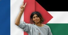 Rima Hassan, a French MEP, raises a peace sign against a backdrop blending the French and Palestinian flags. This image relates to pro-Palestinian activism and legal scrutiny in France.