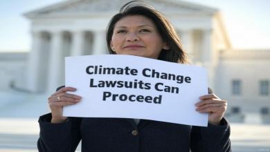 Supreme Court Allows Climate Change Lawsuits Against Oil and Gas Companies to Proceed woman holding up a sign at the US supreme court