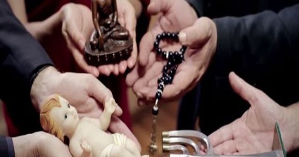 Hands hold religious artifacts: a small Buddha statue, a rosary, and a porcelain baby doll. This image may be relevant to the discussion of Vatican Bible removal or questions about Solomon's character, as it presents a variety of religious symbols.