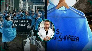Healthcare workers in blue scrubs protest outside the World Medical Association in Rotterdam beside a named empty scrub and a portrait of Dr Hussam Abu Safiya