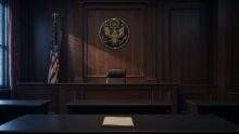 Modified photograph of an empty federal courtroom with an American flag and judicial seal