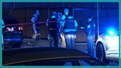 Chicago police investigators stand behind police tape at night in Little Village after an off-duty officer shooting