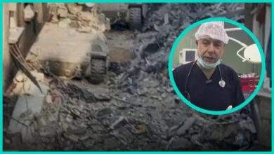 Dr Hussam Abu Safiya in a bright teal frame over rubble left after Israeli forces raided Kamal Adwan Hospital
