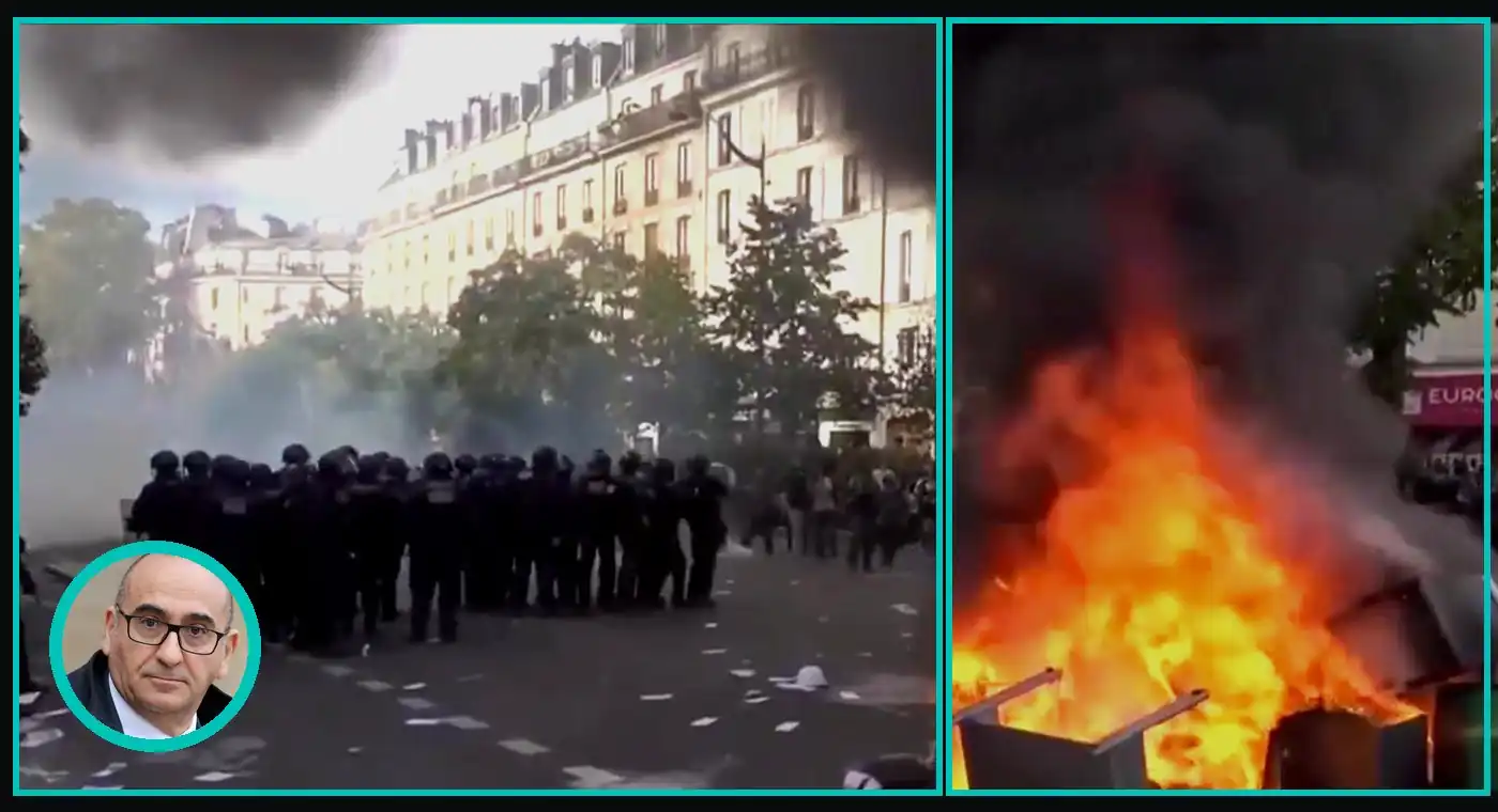 Riot police in a line on a Paris street beside a burning barricade, with Interior Minister Laurent Nuñez shown in a bright teal oval