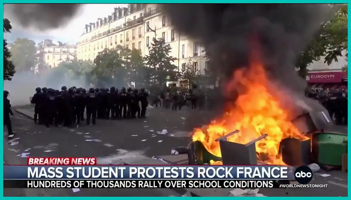 X video screenshot of French student protests and riot police Screenshot of riot police beside a burning barricade during mass student protests in France over school conditions